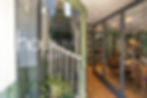 entrance of House Arundel Boutique Bed & Breakfast welcomes guests with its stylish interior and comfortable lounge visible through the glass door.